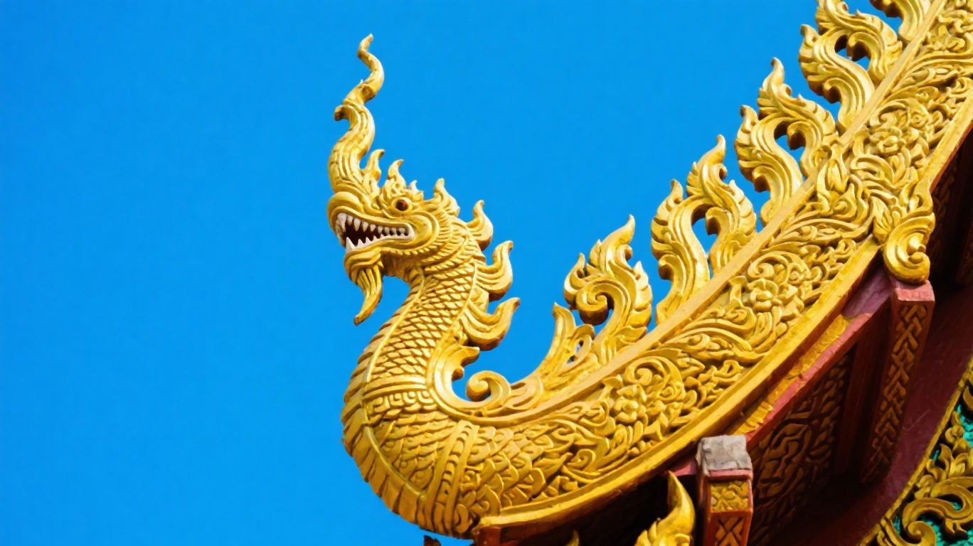 Ornate golden detail on a Chiang Mai temple roof against blue sky